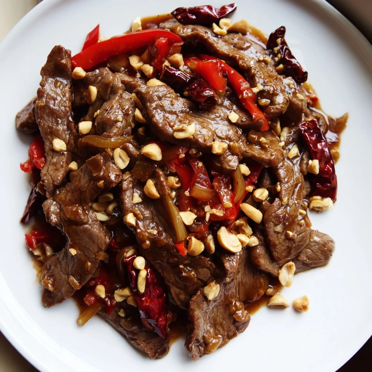 Tender beef slices and chopped peanuts in a glossy red Szechuan sauce over steamed rice.