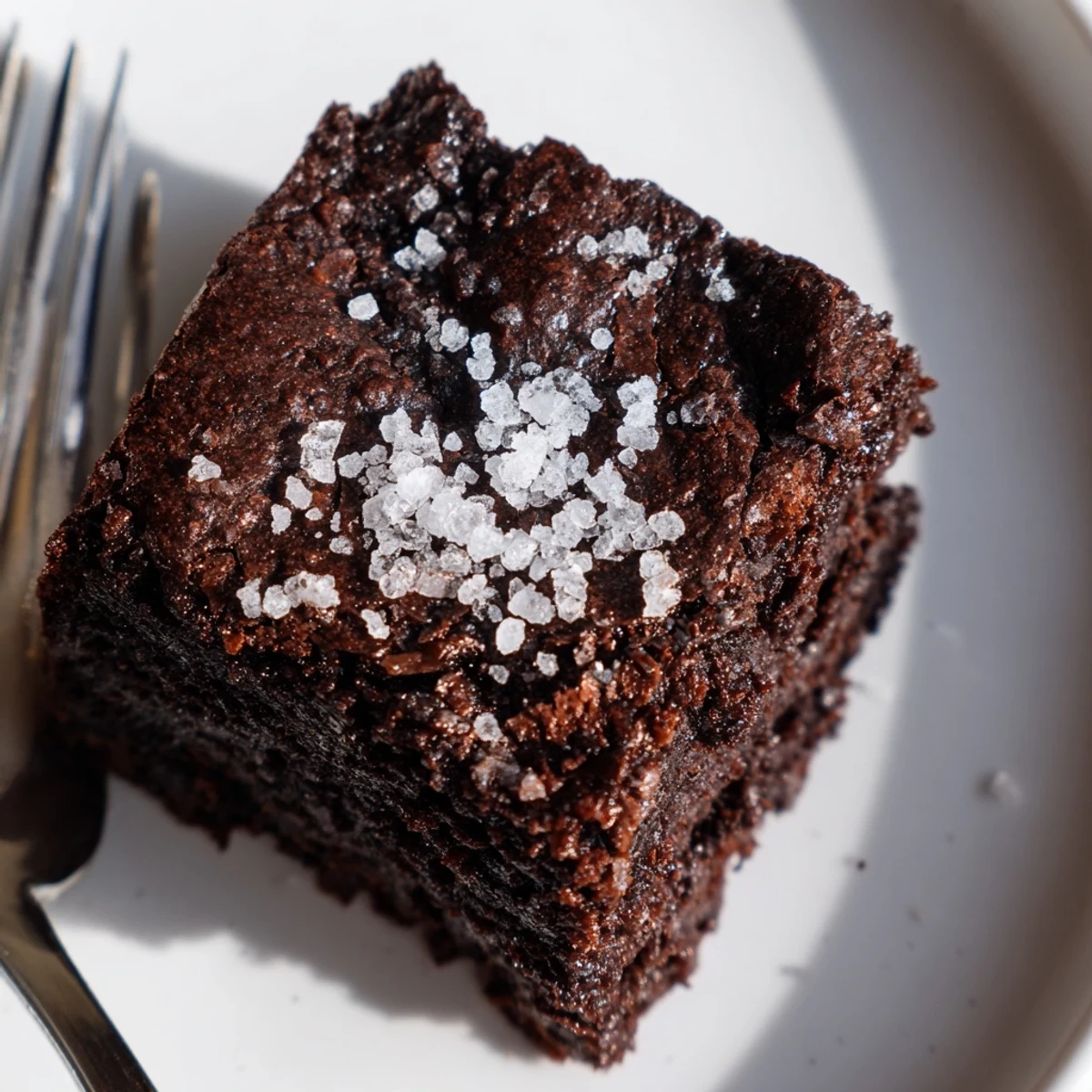 A close-up of rich Chocolate Fudge Brownies with Sea Salt served with vanilla ice cream.