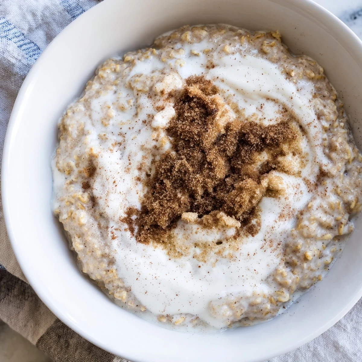 Creamy Irish Oatmeal with Brown Sugar and Cream served in a rustic bowl with a rich drizzle of heavy cream.