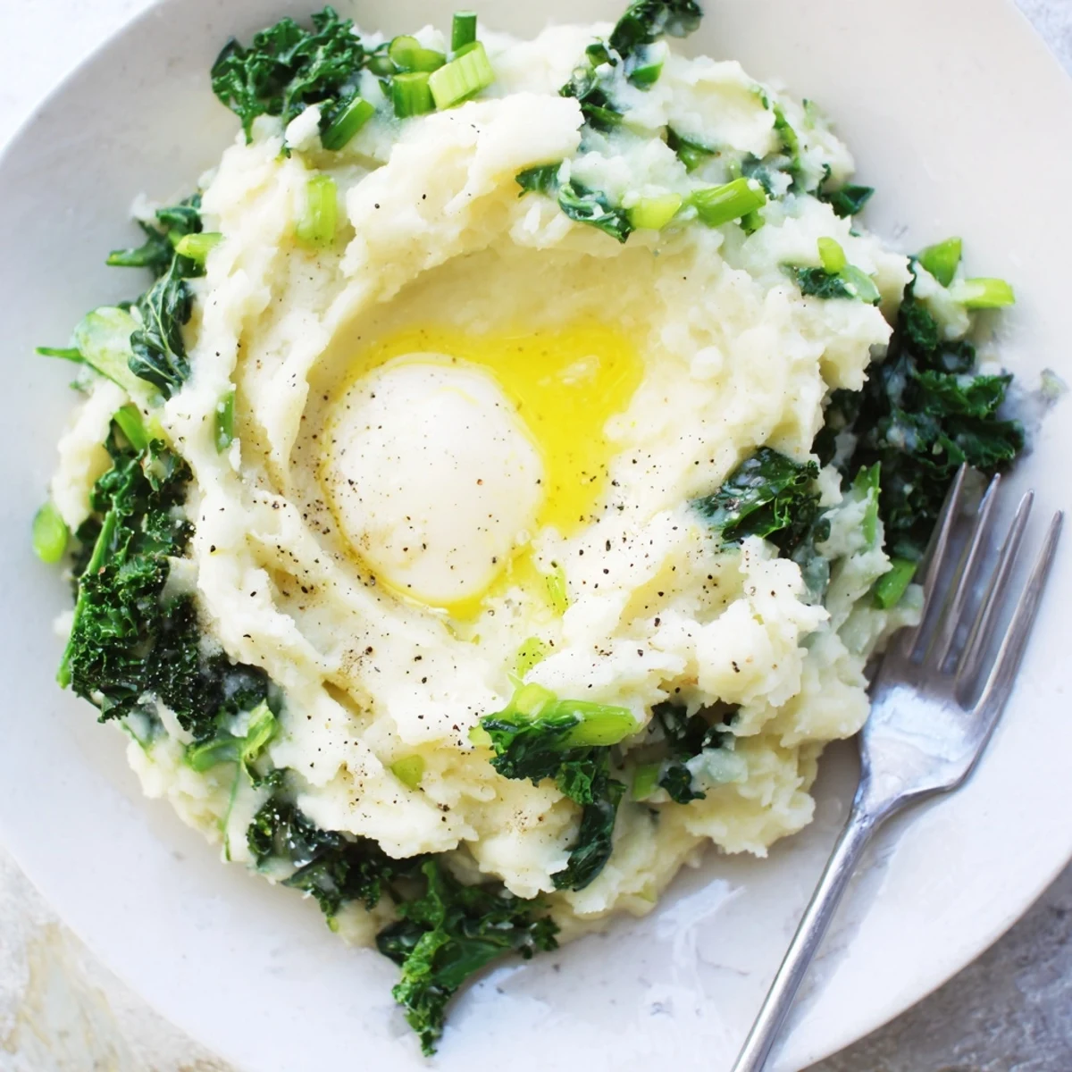 Creamy Irish Colcannon with kale and butter, served warm in a rustic bowl for a comforting side dish.