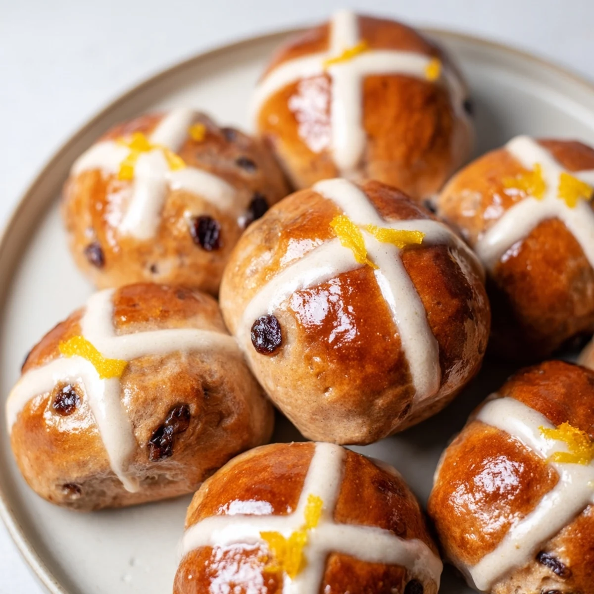 A basket of freshly baked Easter Hot Cross Buns, studded with currants and orange zest for festive flavor.
