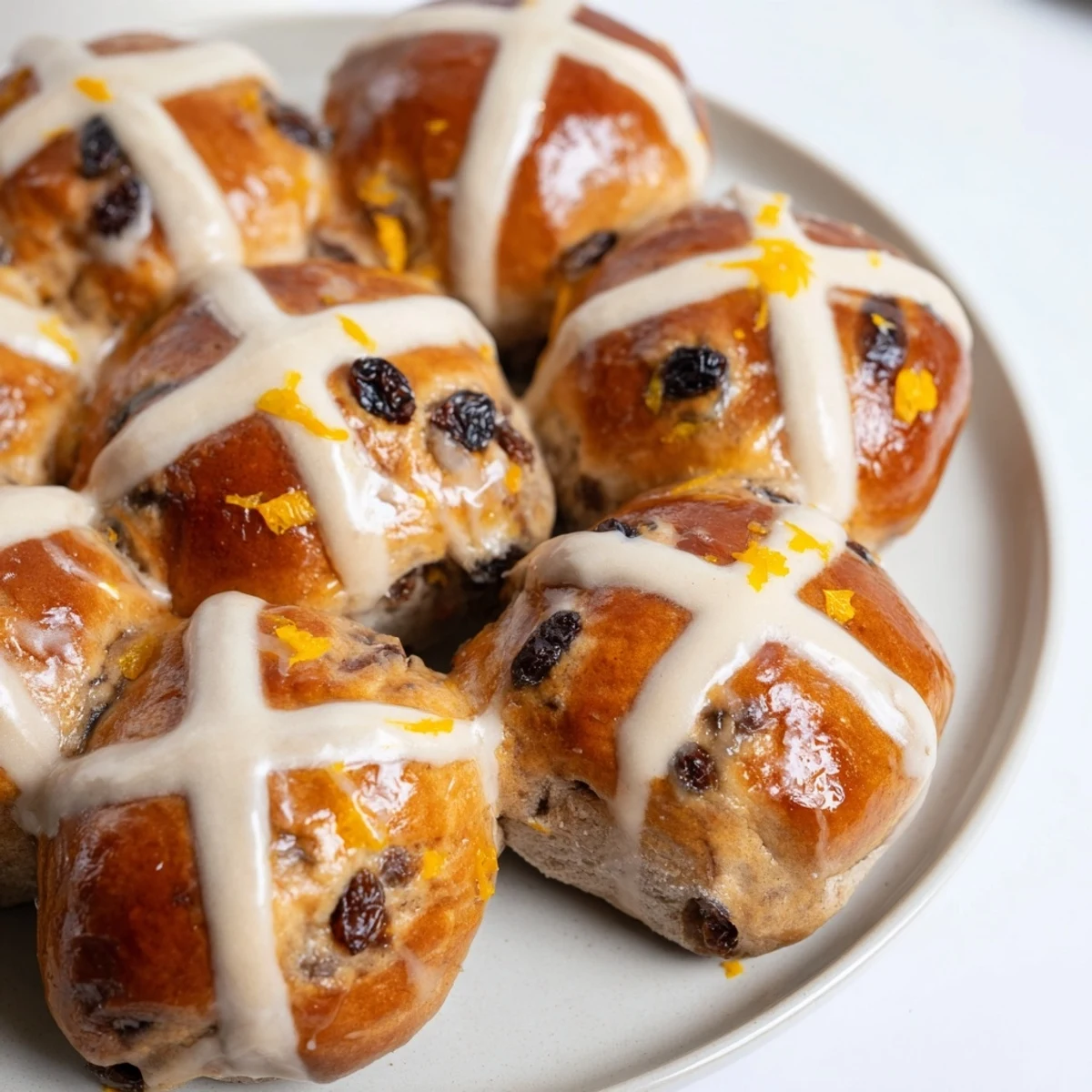 Warm Easter Hot Cross Buns arranged on a cooling rack, ready to serve with a cup of tea.
