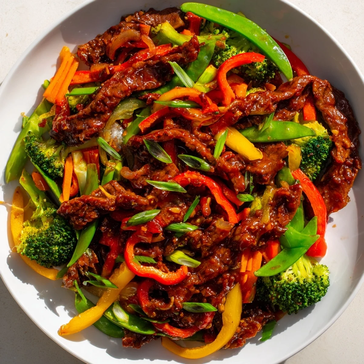 Spicy Beef Stir Fry with Mixed Vegetables sizzles with tender beef strips and vibrant bell peppers in a glossy, aromatic sauce.