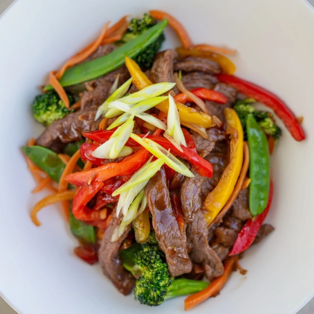 In this Spicy Beef Stir Fry with Mixed Vegetables, crisp broccoli and snap peas glisten alongside juicy beef in a bold red sauce.