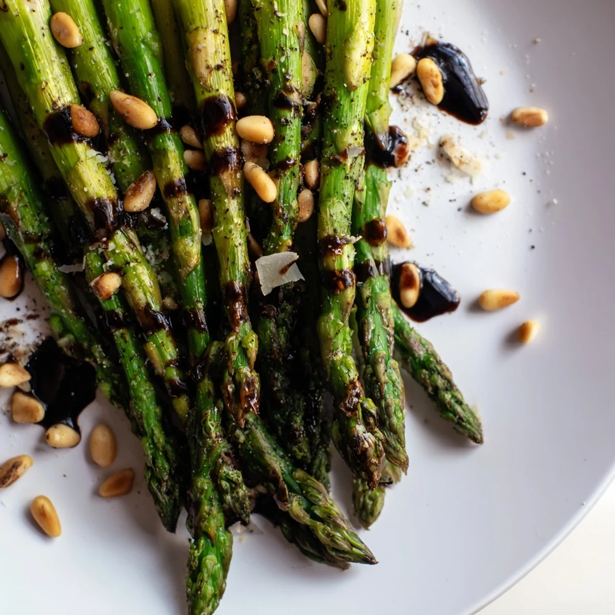 Tender roasted asparagus spears on a platter, drizzled with glossy balsamic reduction for a vibrant side dish.