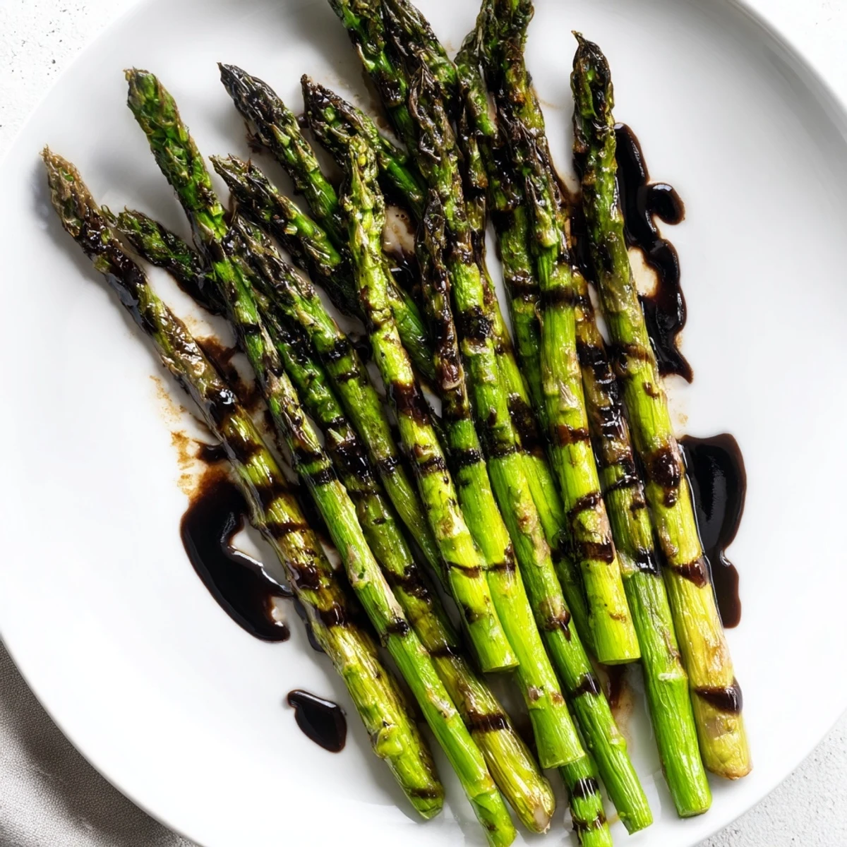 A close-up of golden-brown roasted asparagus with glistening balsamic glaze for dinner.