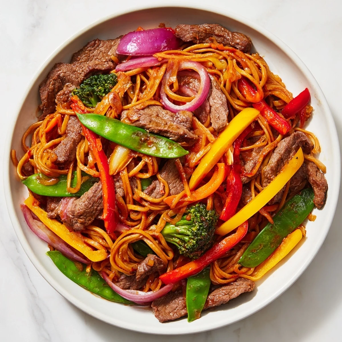 Vibrant platter of Spicy Beef Stir Fry with Mixed Vegetables showcasing tender beef, crisp bell peppers, and snap peas in a glossy sauce.