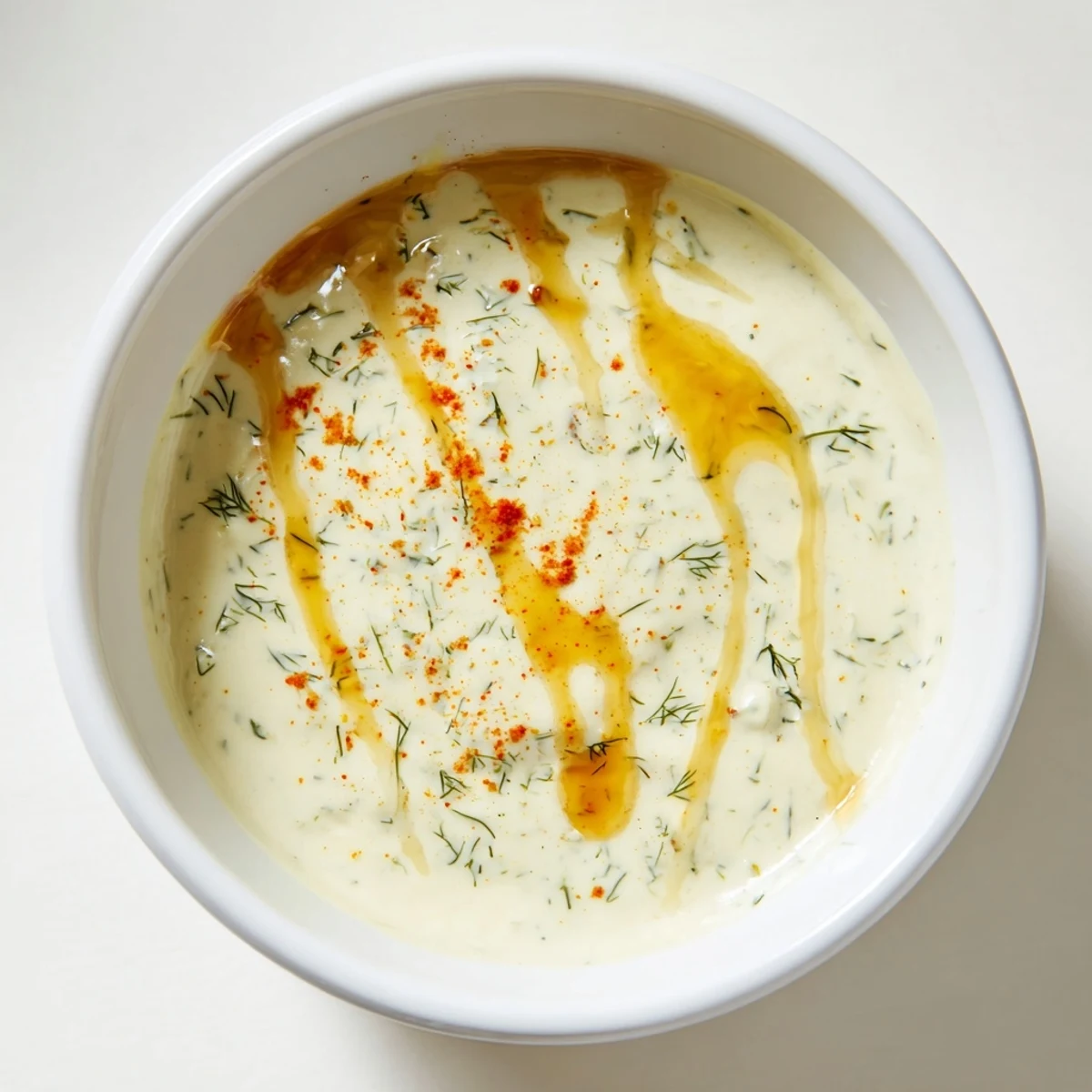 Freshly prepared hot honey ranch crispy chicken tenders sauce beside golden crispy chicken tenders on a rustic wooden board.