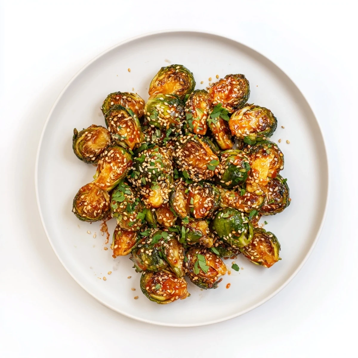 Close-up of roasted Honey Sriracha Brussels sprouts topped with cilantro, perfect as a spicy appetizer or side.  