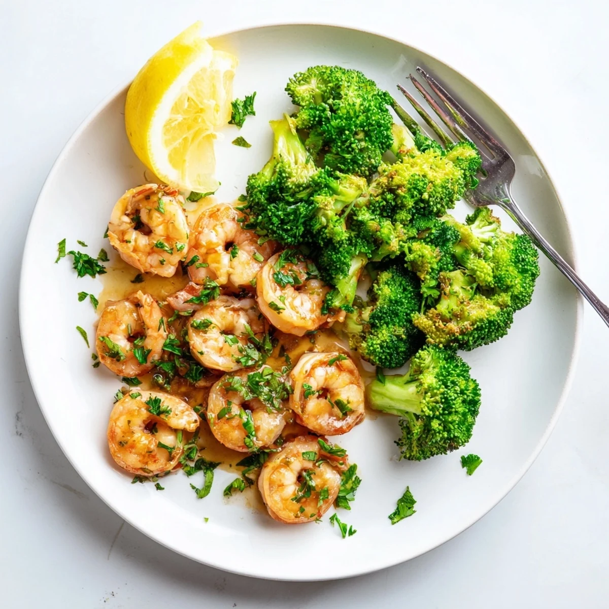 A close-up of Honey Garlic Butter Shrimp & Broccoli glistening with sauce over fluffy rice, with bright green broccoli florets.