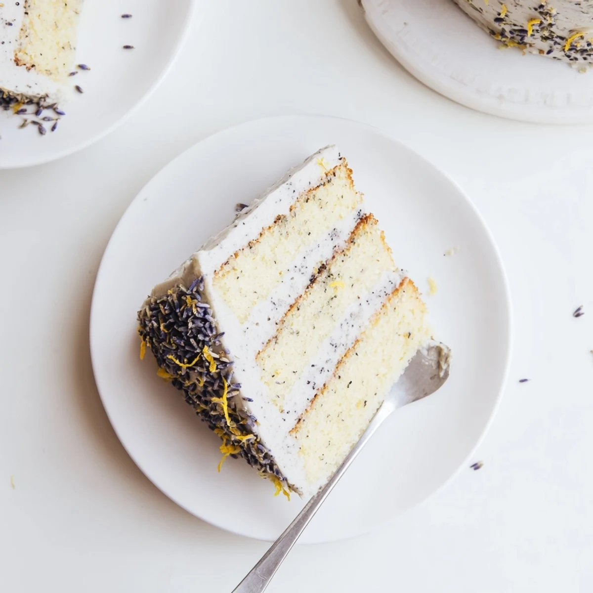A close-up of the London Fog Cake with Earl Grey & Lavender, showing creamy vanilla frosting and delicate lavender buds.