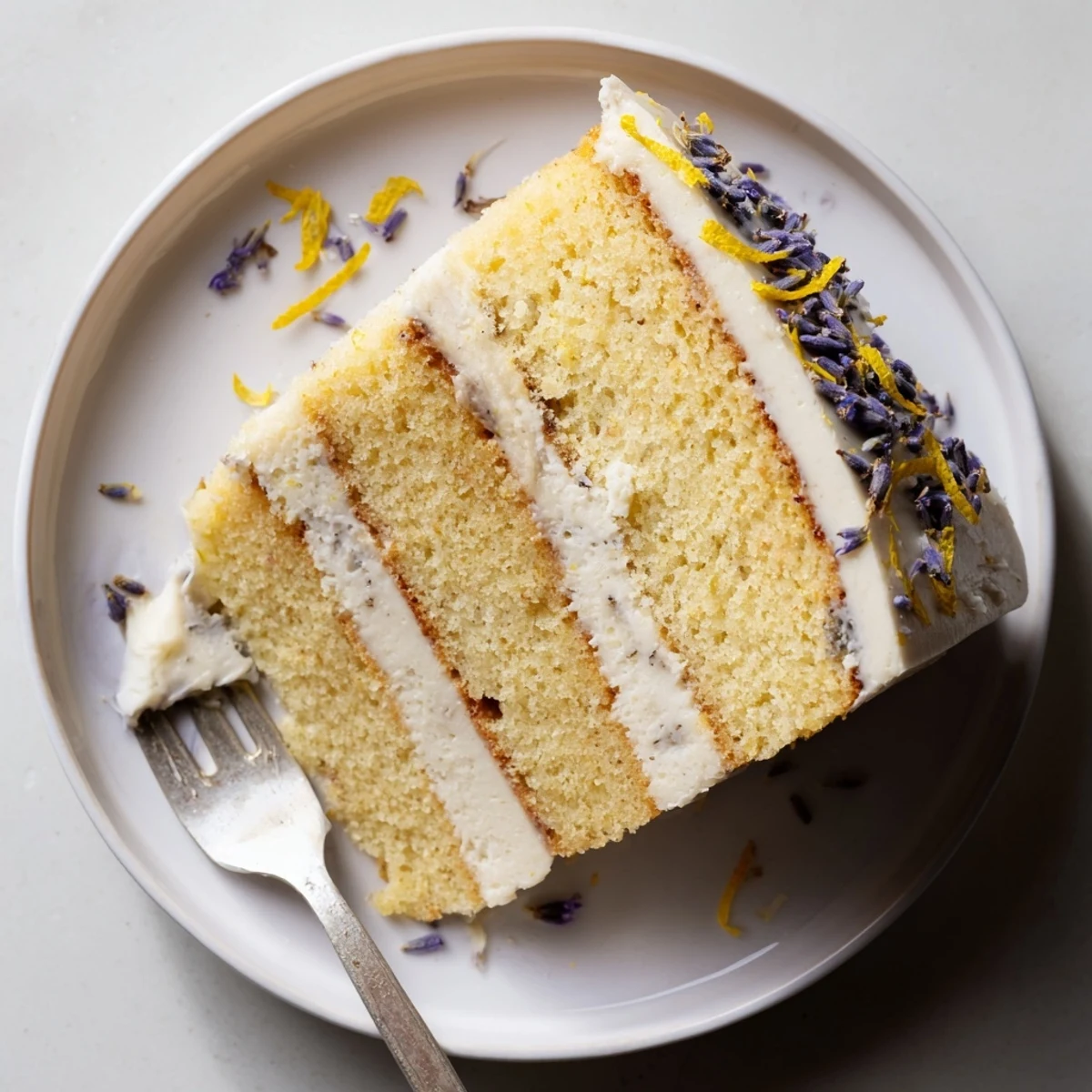 A slice of London Fog Cake with Earl Grey & Lavender reveals moist tea-infused layers and a vanilla bean frosting swirl.