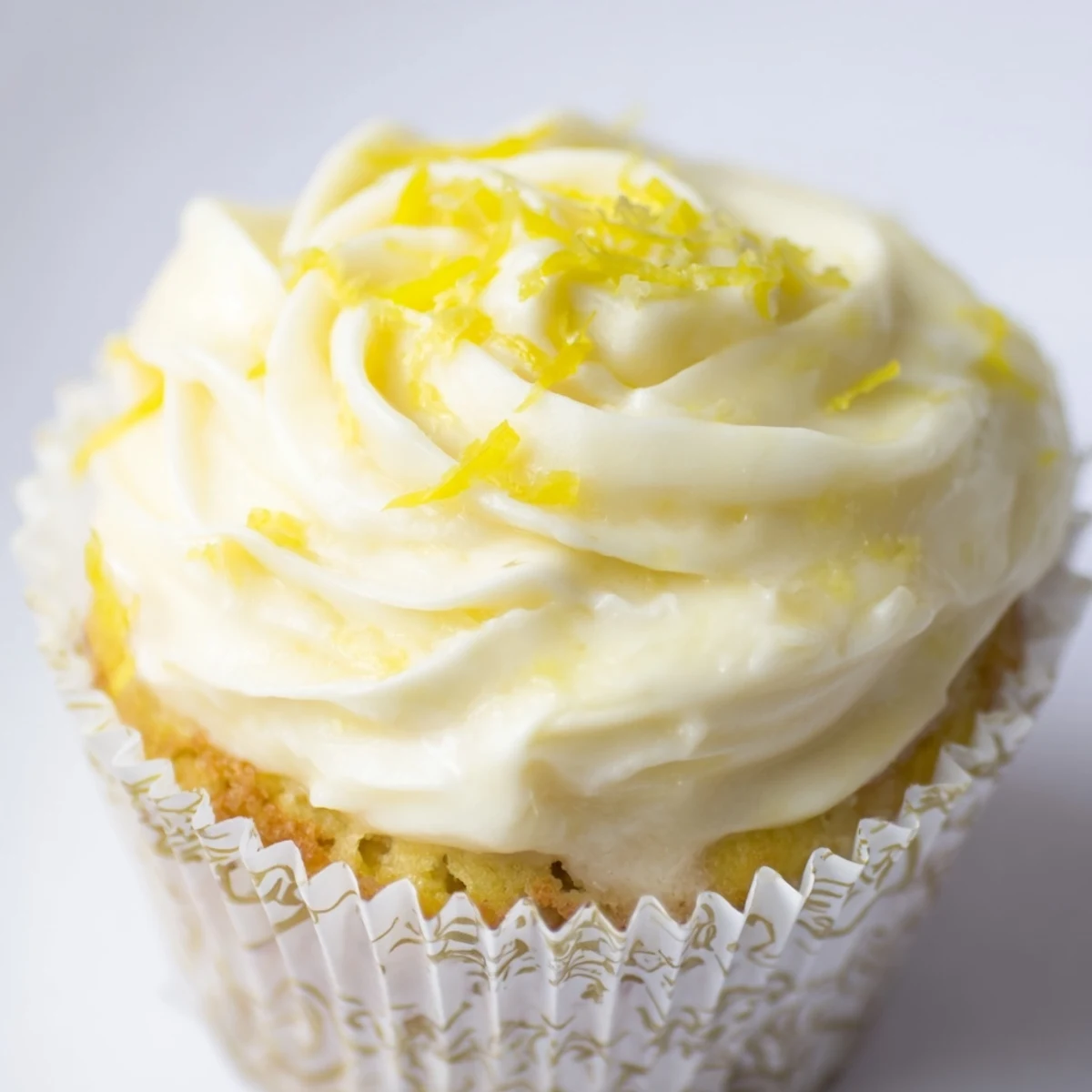 Overhead view of frosted Limoncello Cupcakes garnished with lemon zest, perfect for a spring or summer dessert table in the kitchen.