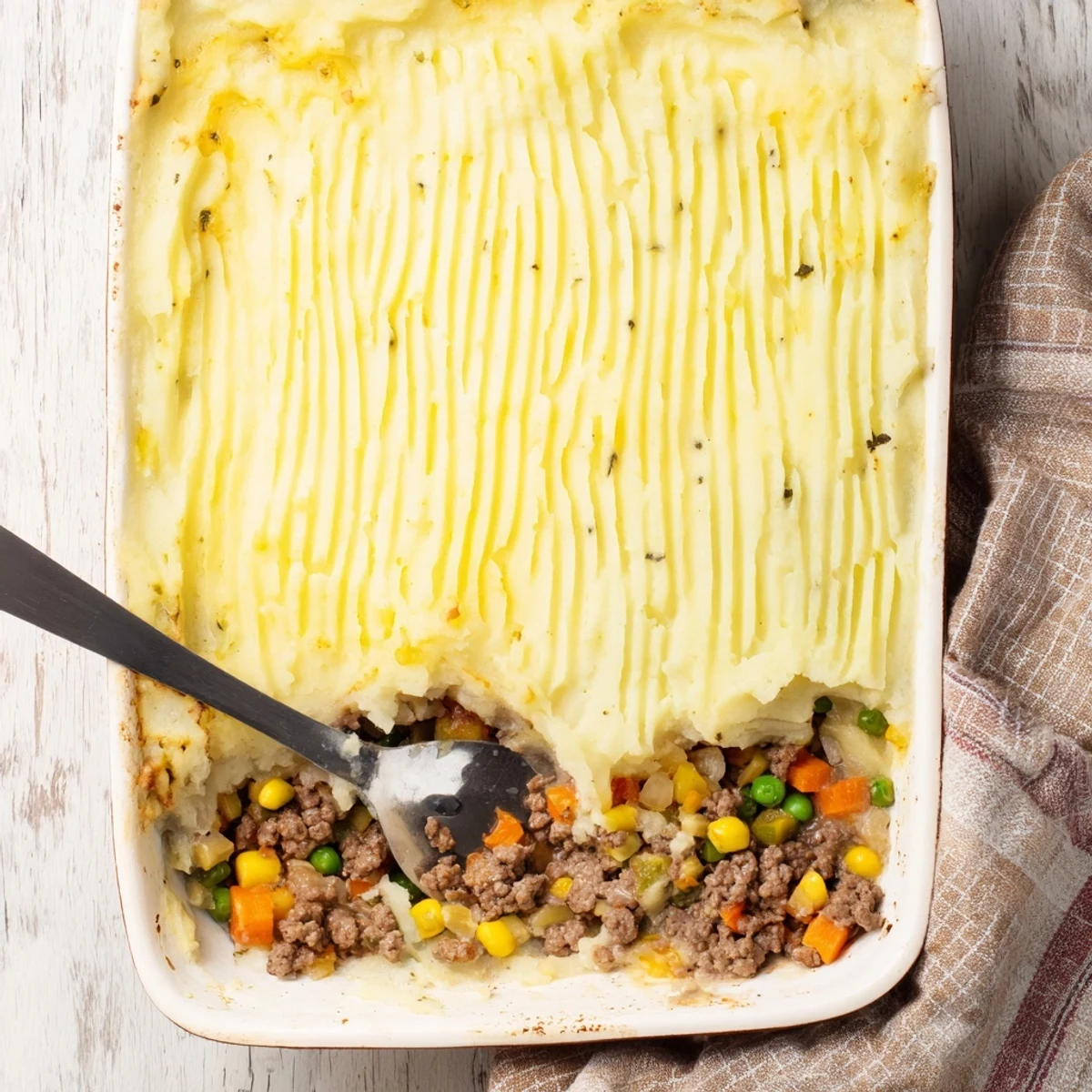 Comforting Easy Shepherds Pie baked until golden, with a hearty meat filling and smooth potato topping in a casserole.