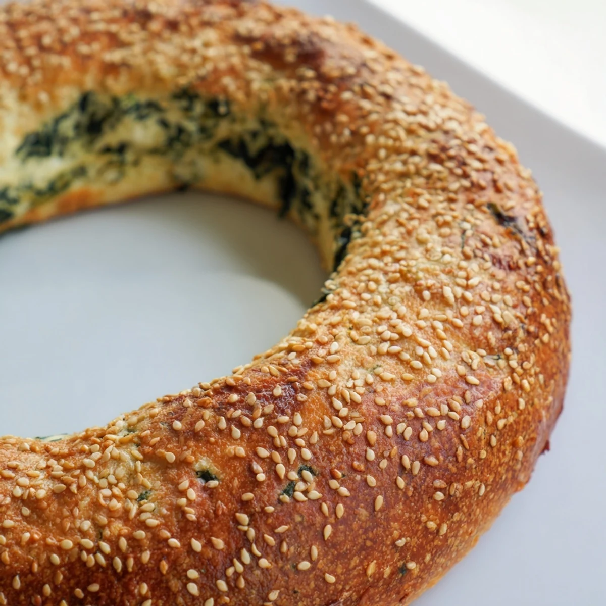 Sliced Spinach Cottage Cheese Flagels reveal a fluffy, green-flecked interior, perfect for toasting and serving with butter or cream cheese. 