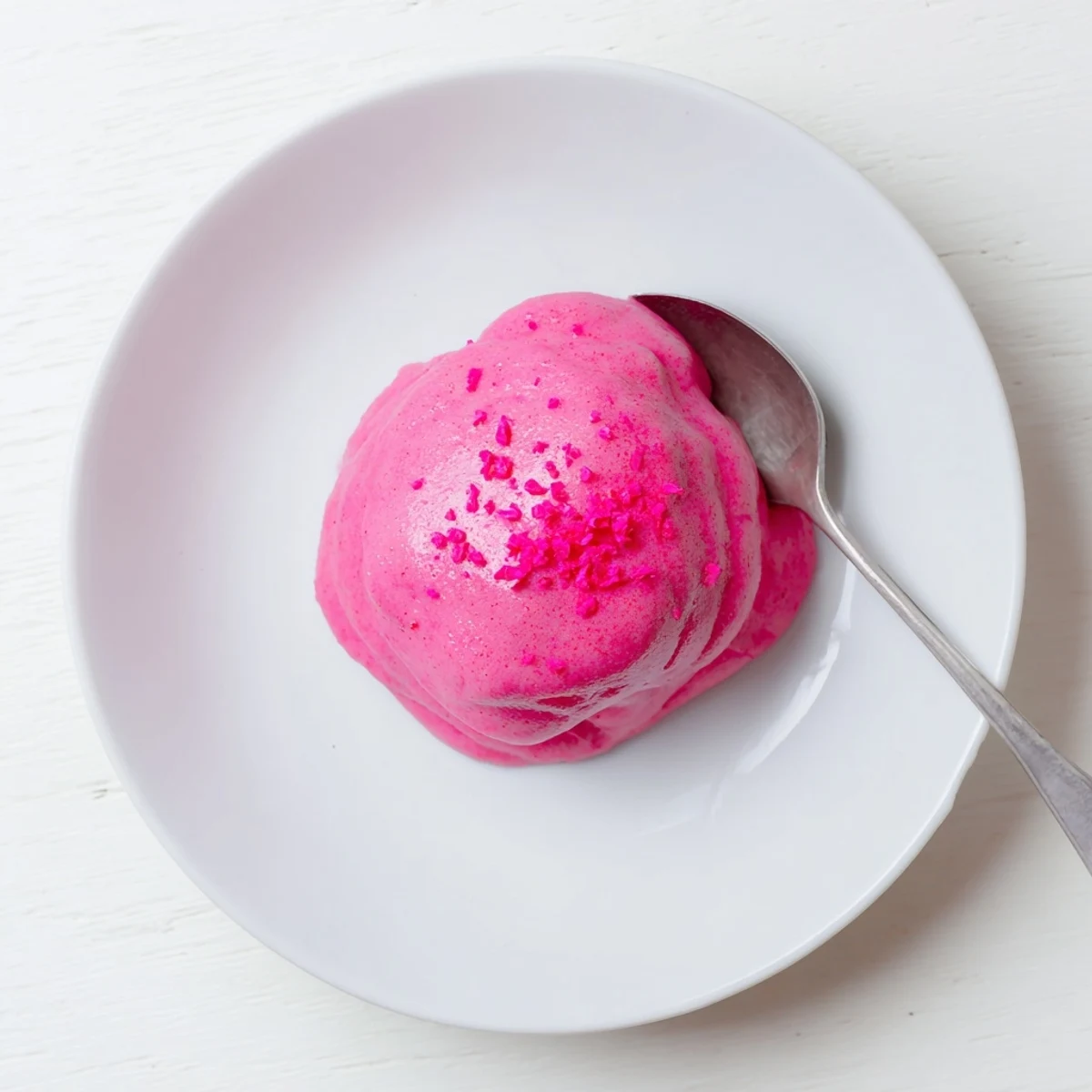 Vibrant pink lemon curd spread thickly on a fresh scone