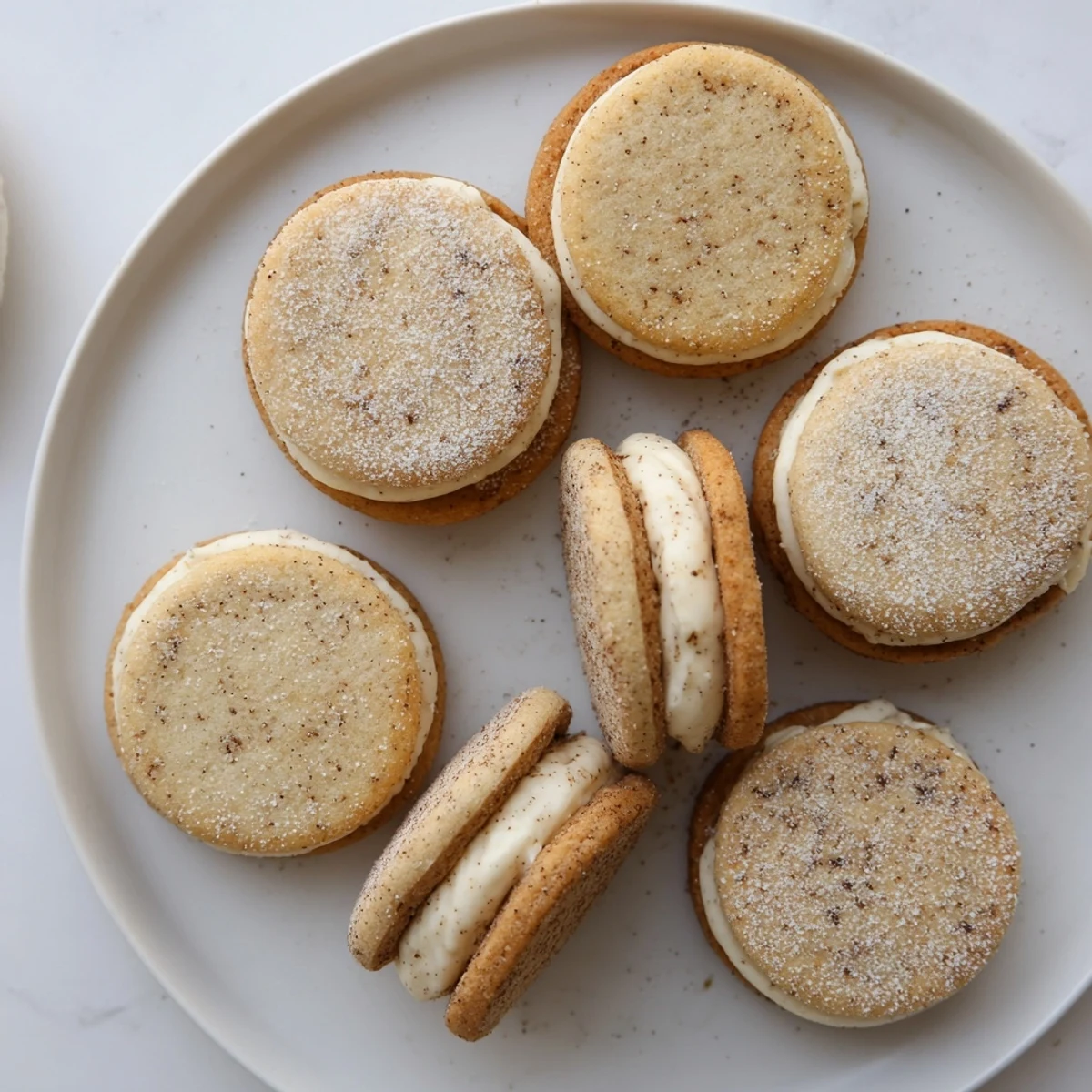Golden chai shortbread cookie sandwiches with creamy spiced filling between two buttery cookies