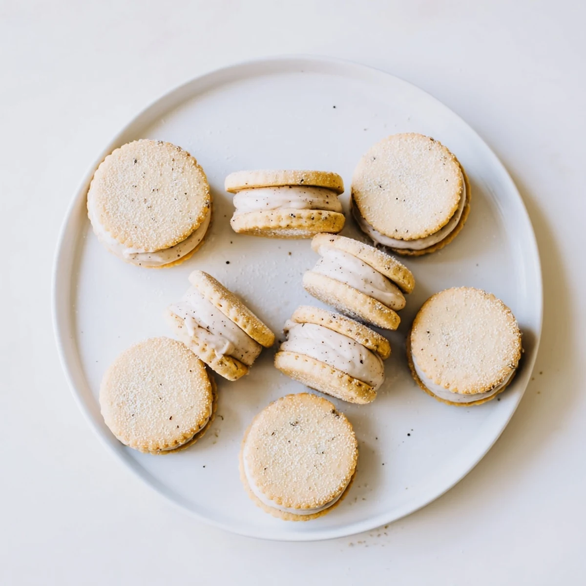 Close-up of chai shortbread cookie sandwiches showing warm spices and white cream filling layers