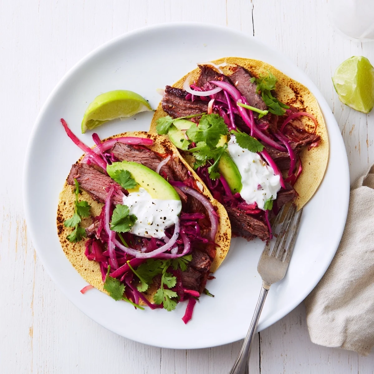 Golden roasted leg of lamb with aromatic cumin spice crust nestled inside soft corn tortillas alongside vibrant shredded cabbage and creamy yogurt
