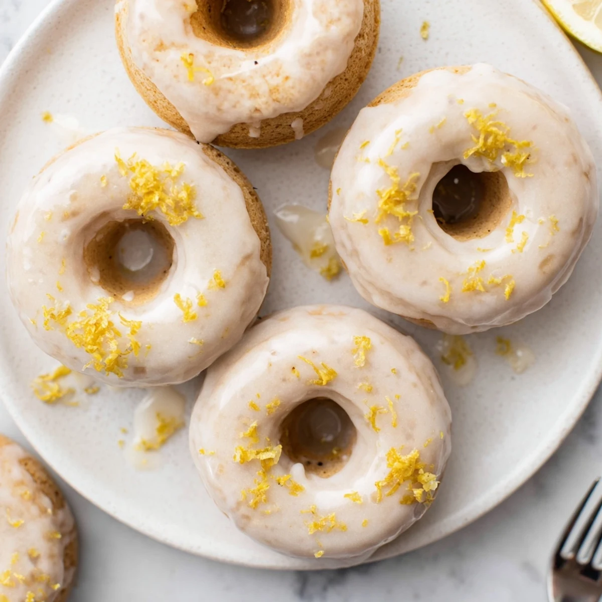 Chewy gluten-free lemon mochi donuts topped with tangy white glaze and zest