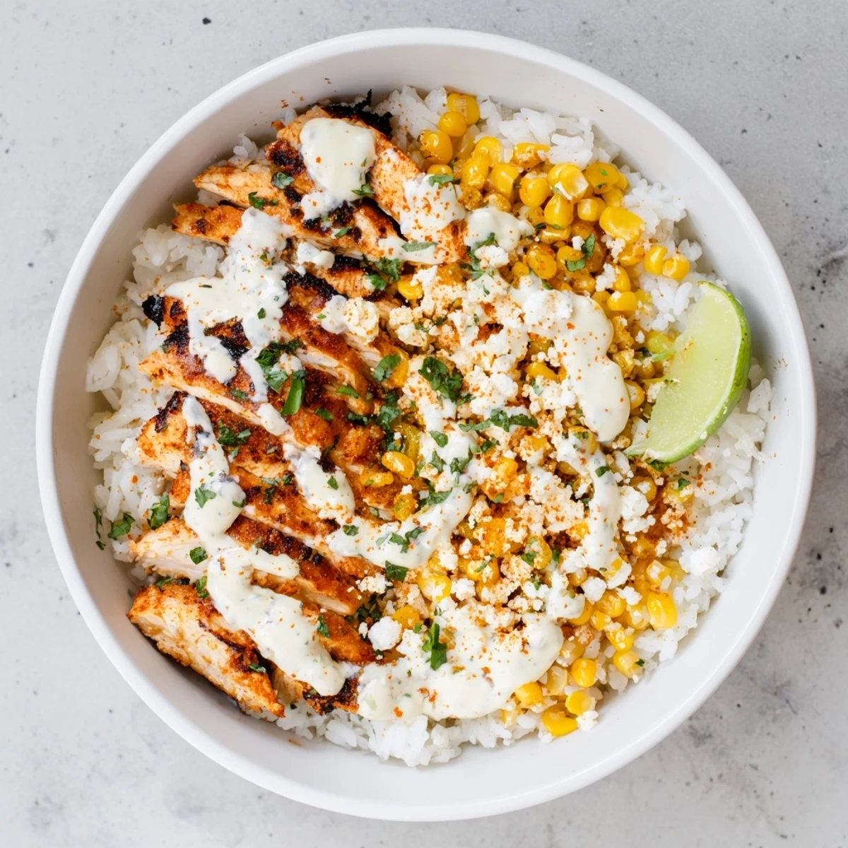 Golden street corn chicken rice bowl topped with zesty crema and crumbled cotija cheese