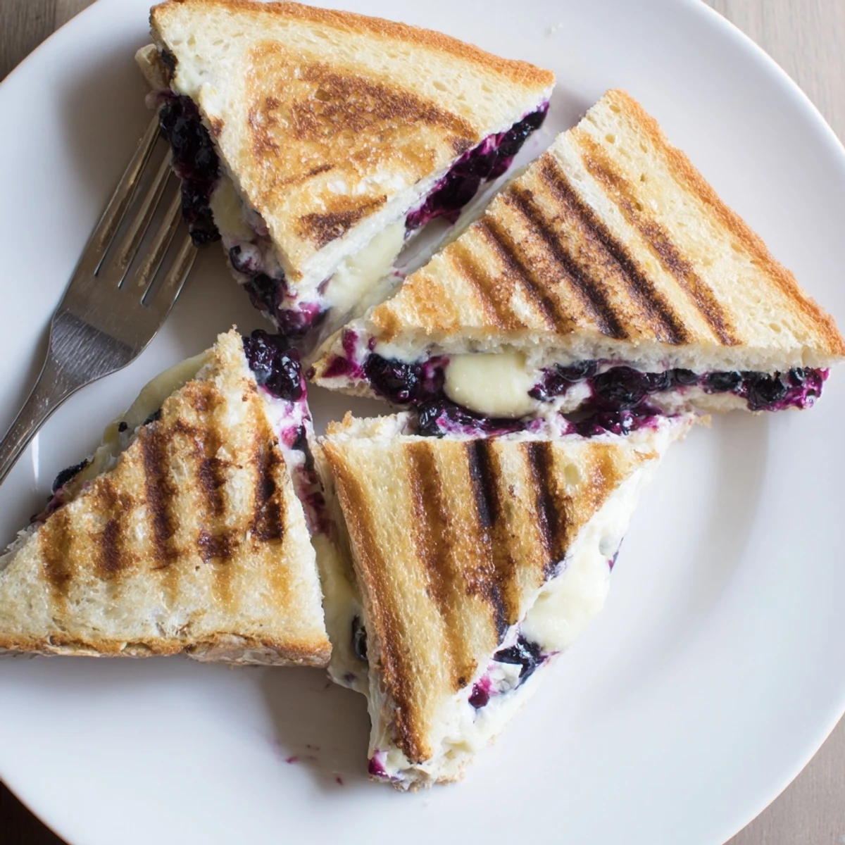 Buttery sourdough grilled cheese with warm blueberry filling and melted white cheddar layers