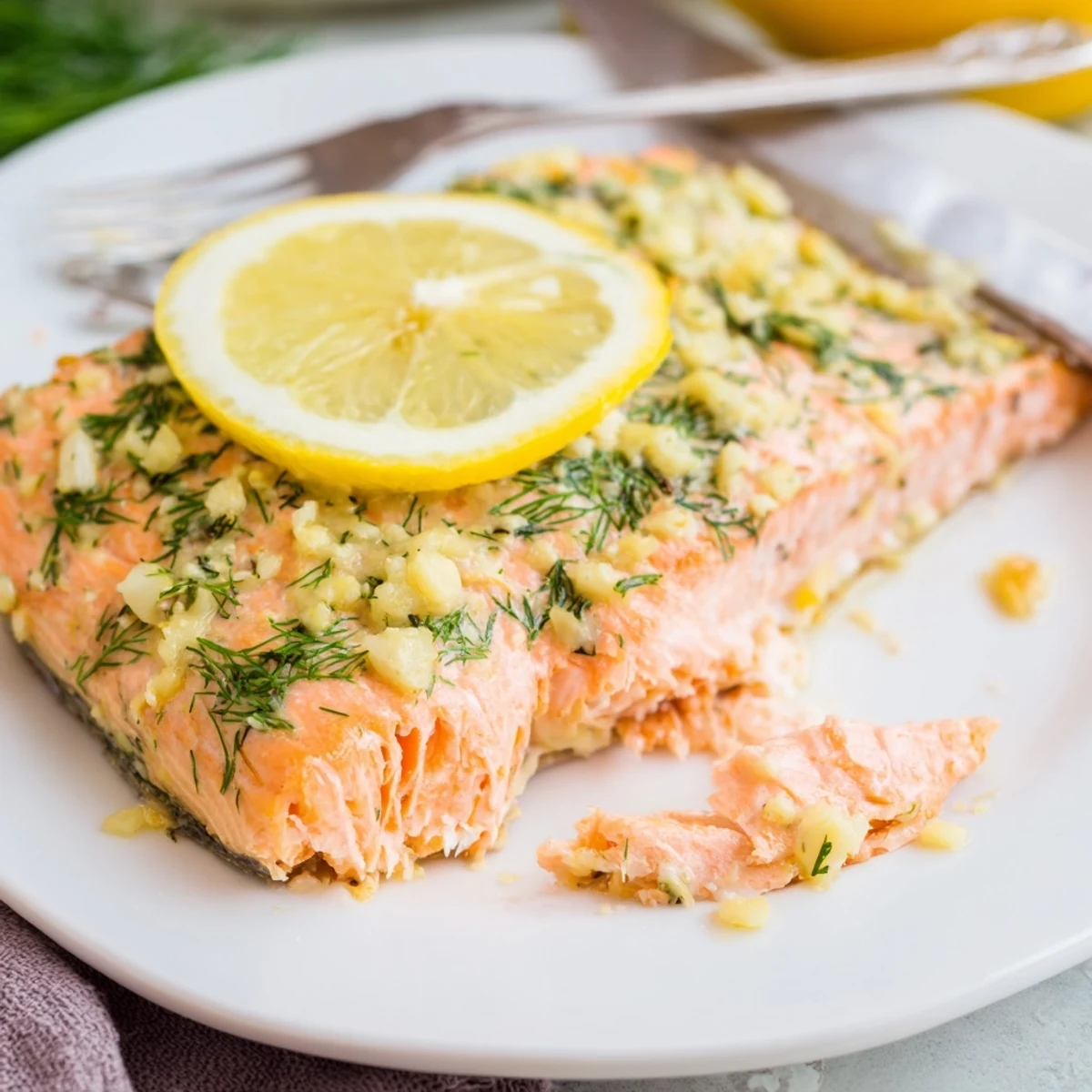 Tender flaky baked salmon with crispy lemon slices on a white serving plate