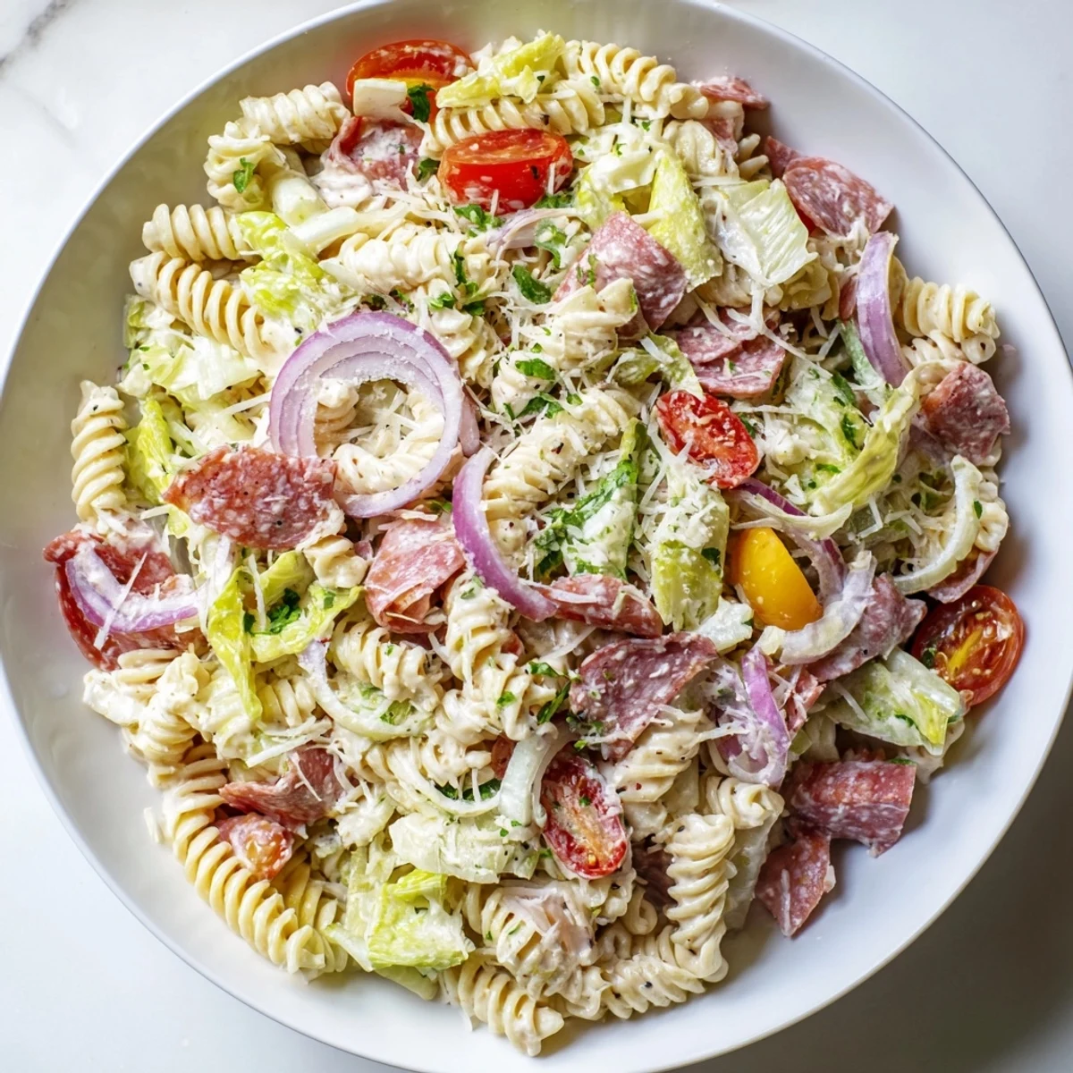 Hearty Italian grinder pasta salad featuring rotini noodles tossed with salami, ham, provolone, and fresh crunchy veggies