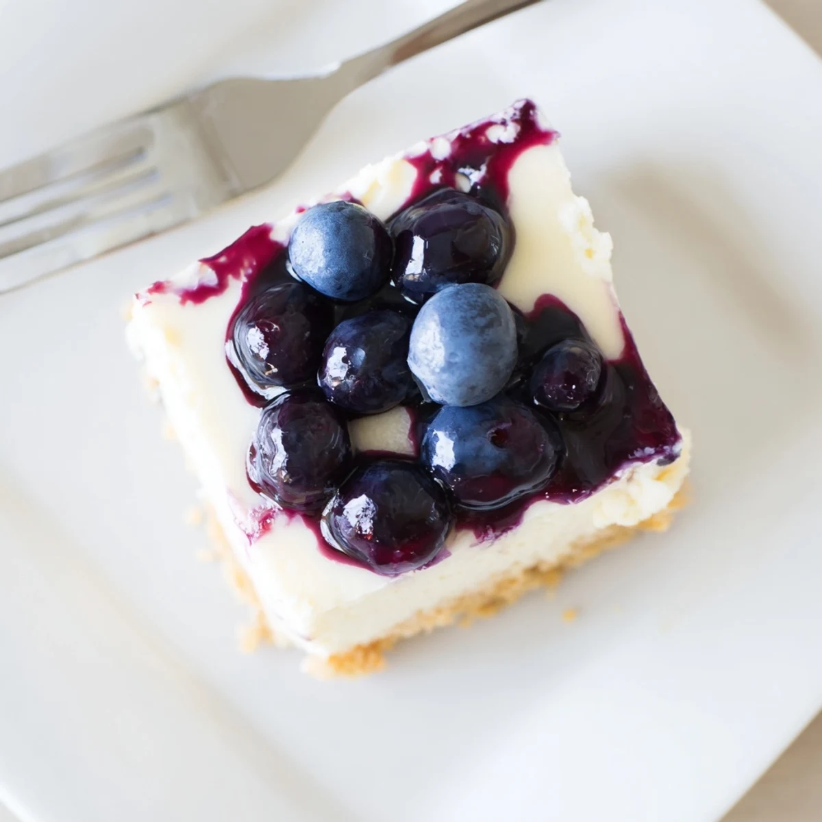 Golden buttery pecan crust topped with creamy cheesecake layer and glossy sweet-tart blueberry jamboree dessert
