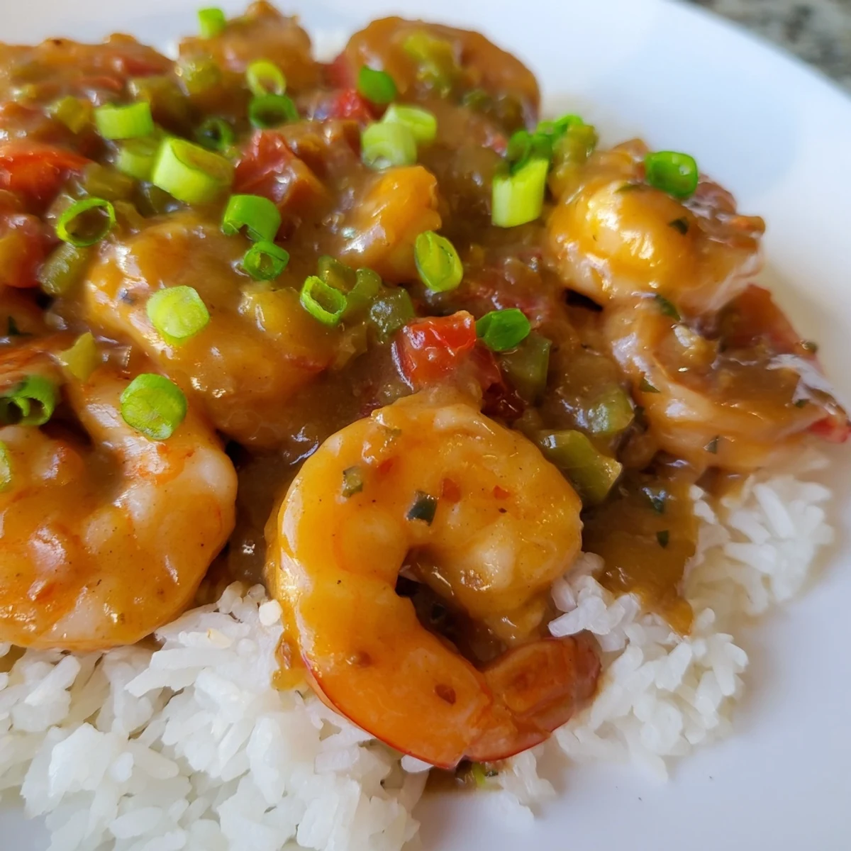 Classic Louisiana shrimp étouffée featuring tender seafood in a spicy dark roux with vegetables