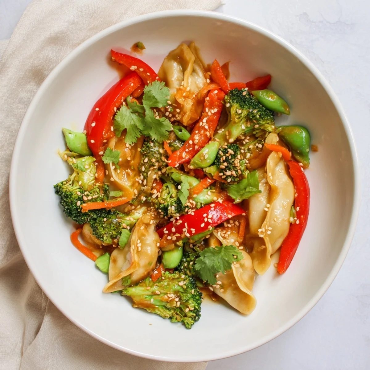 Golden pan-fried dumpling stir fry with colorful vegetables coated in glossy garlic sauce