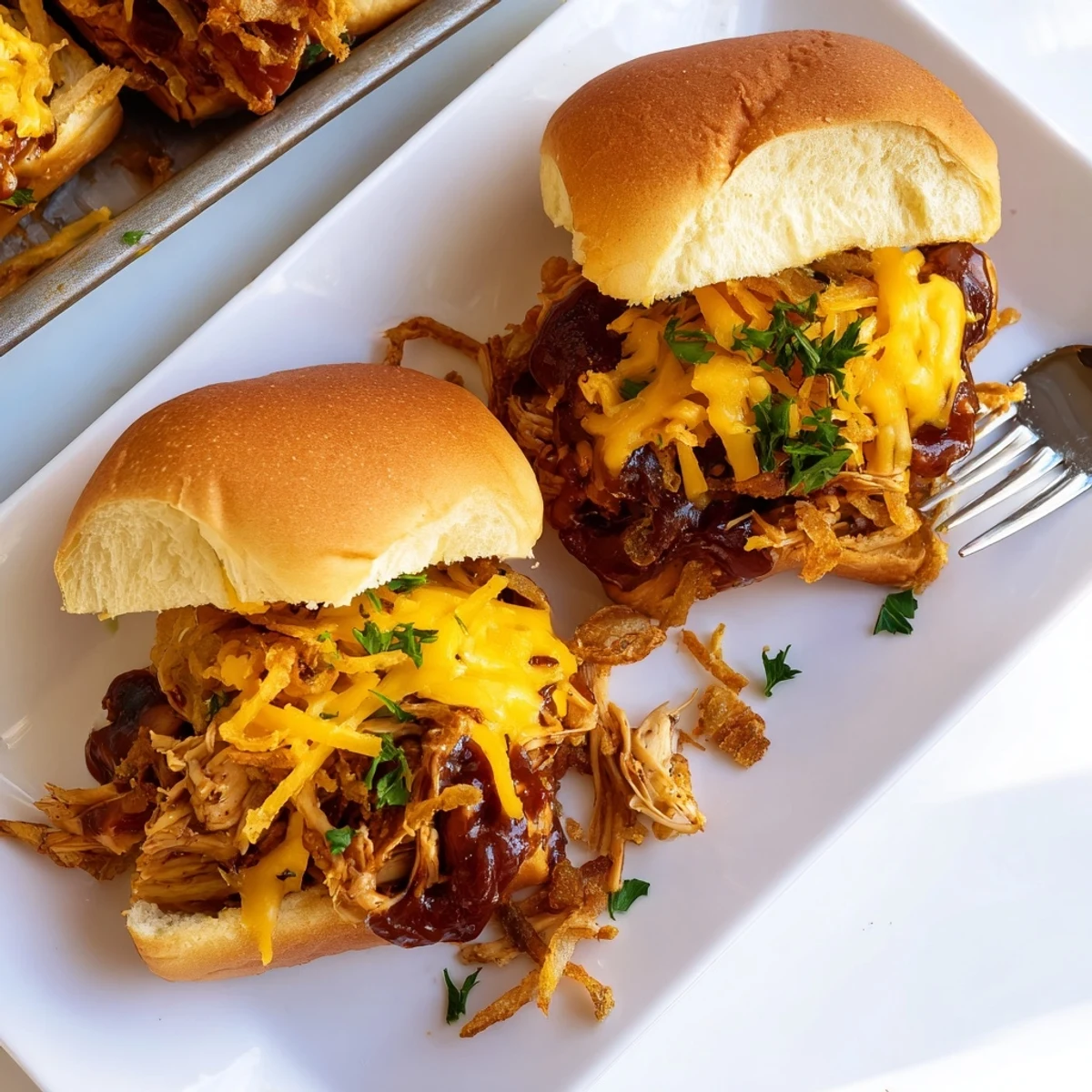 Baked Mississippi Mud Chicken Sliders featuring shredded chicken in smoky sauce with cheese and crispy toppings on soft buns