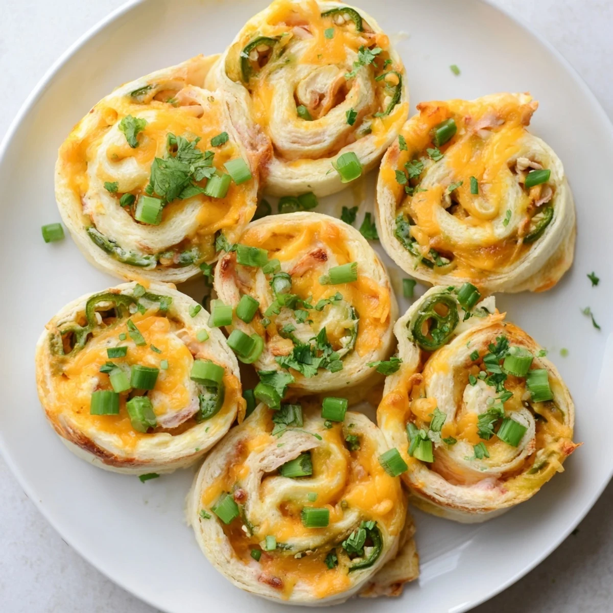 Flour tortilla rolls stuffed with creamy jalapeño cheese filling sliced into appetizer pinwheels