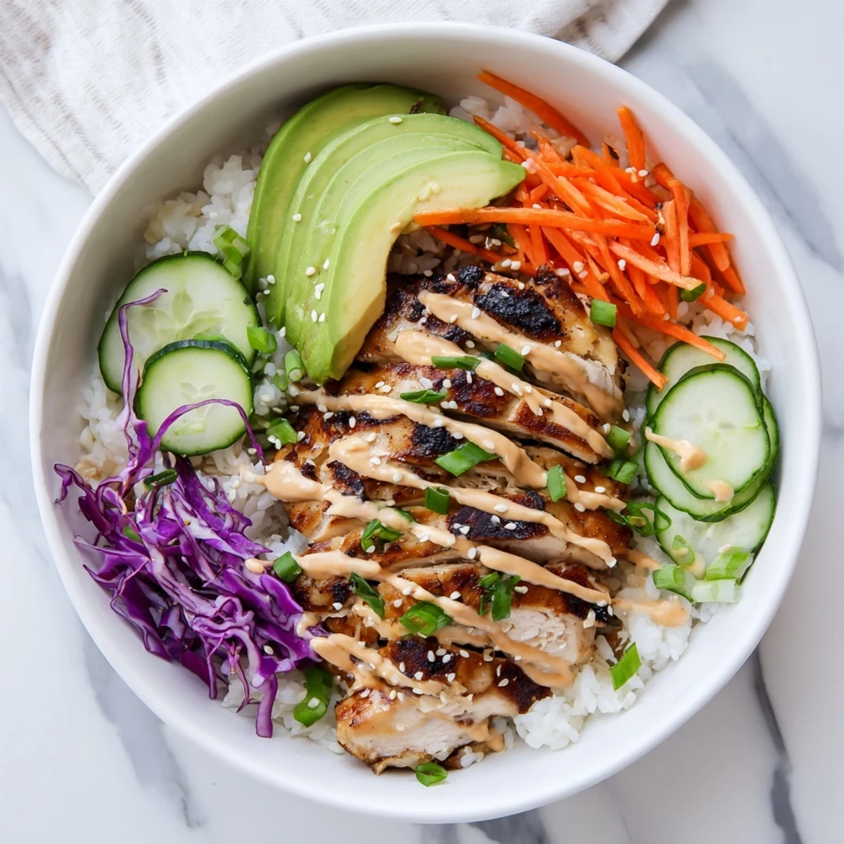 Succulent Korean BBQ chicken slices arranged over steaming jasmine rice with fresh vegetable toppings and a drizzle of spicy gochujang mayonnaise.
