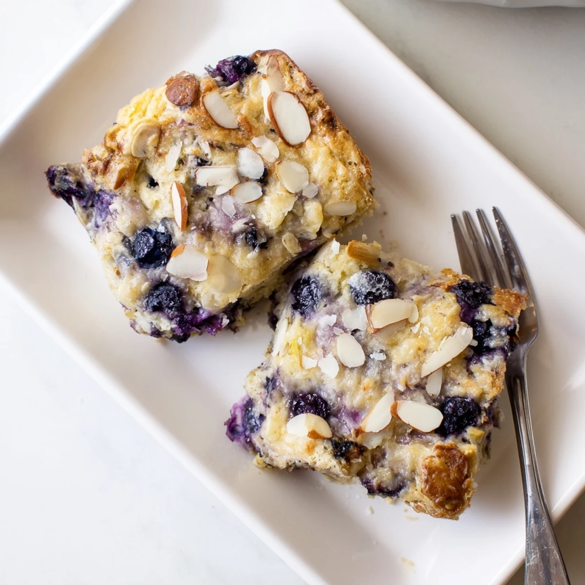 Rustic baked oatmeal casserole dotted with fresh blueberries and crunchy walnuts