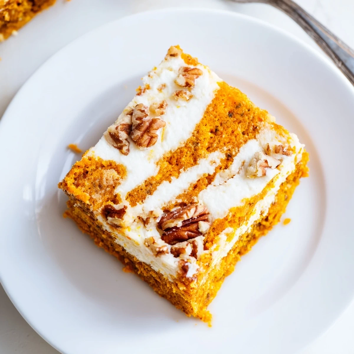 Moist carrot cake cream cheese bars cut into squares showing beautiful marbled cream cheese swirls