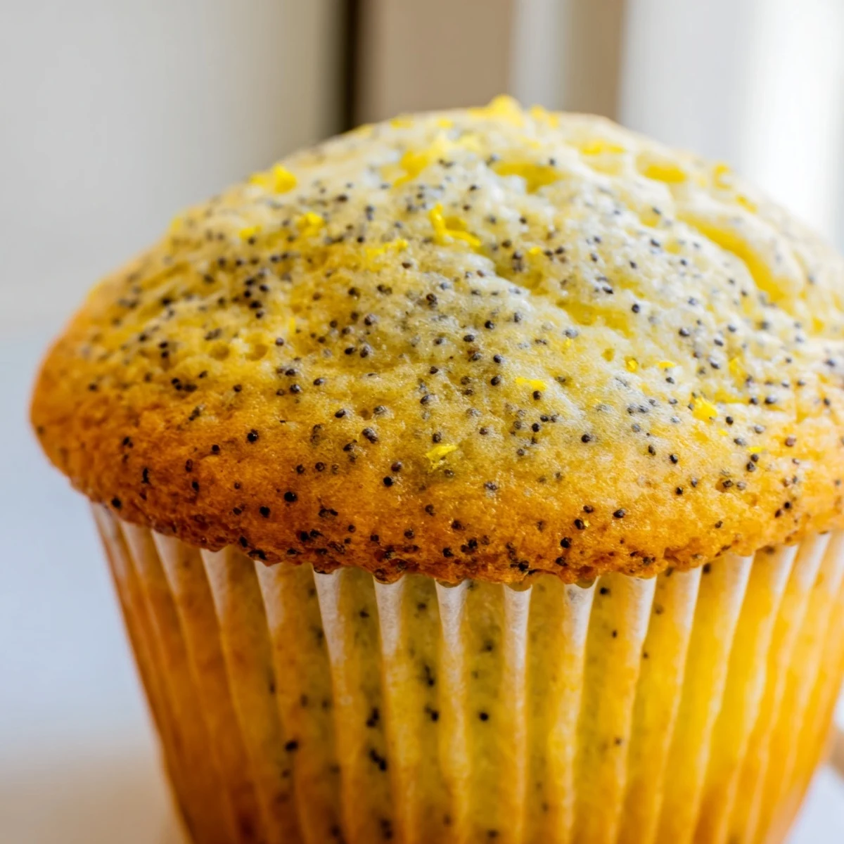 Golden lemon poppy seed muffins with domed tops fresh from the oven on a wire cooling rack