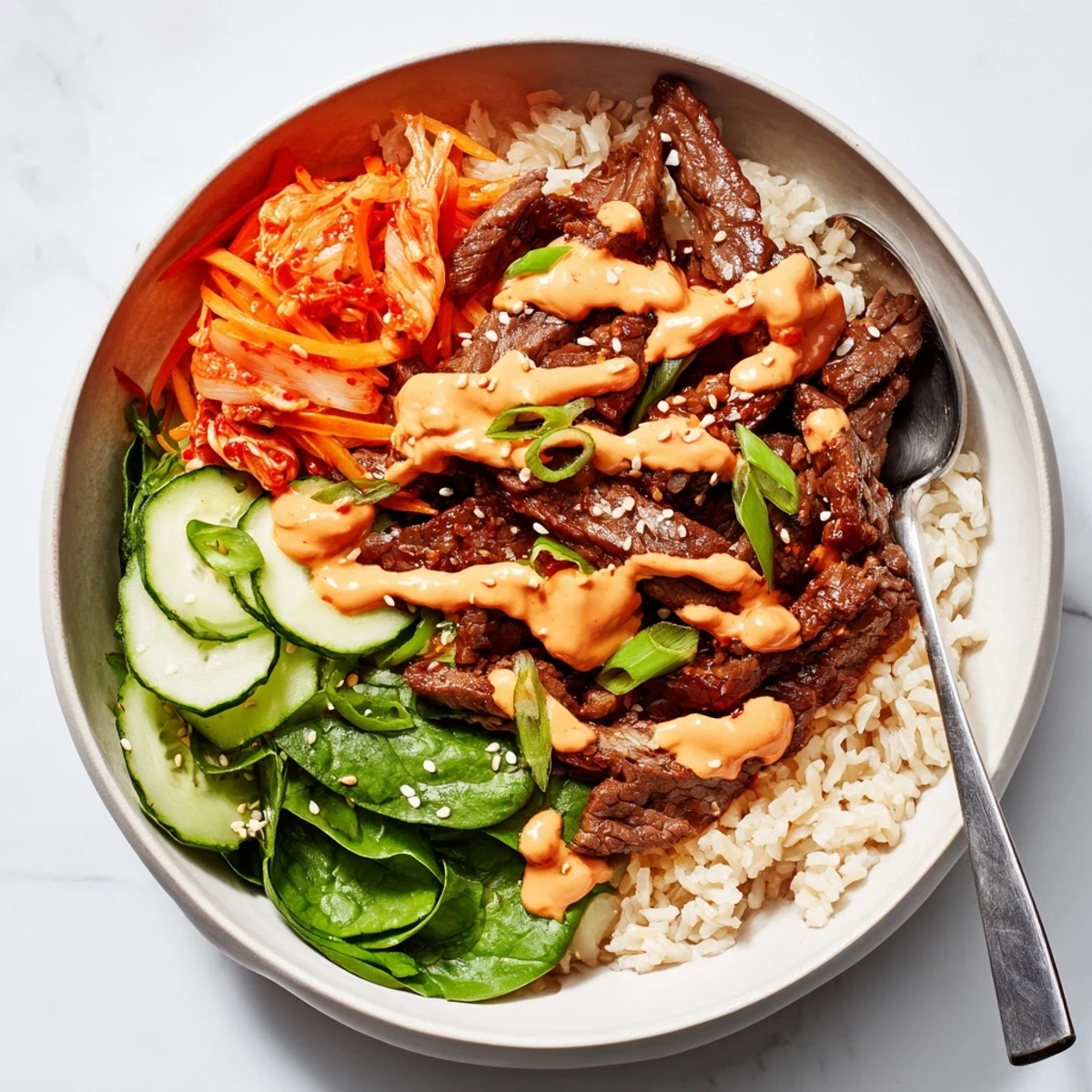 A loaded Korean BBQ steak rice bowl topped with kimchi and sesame seeds