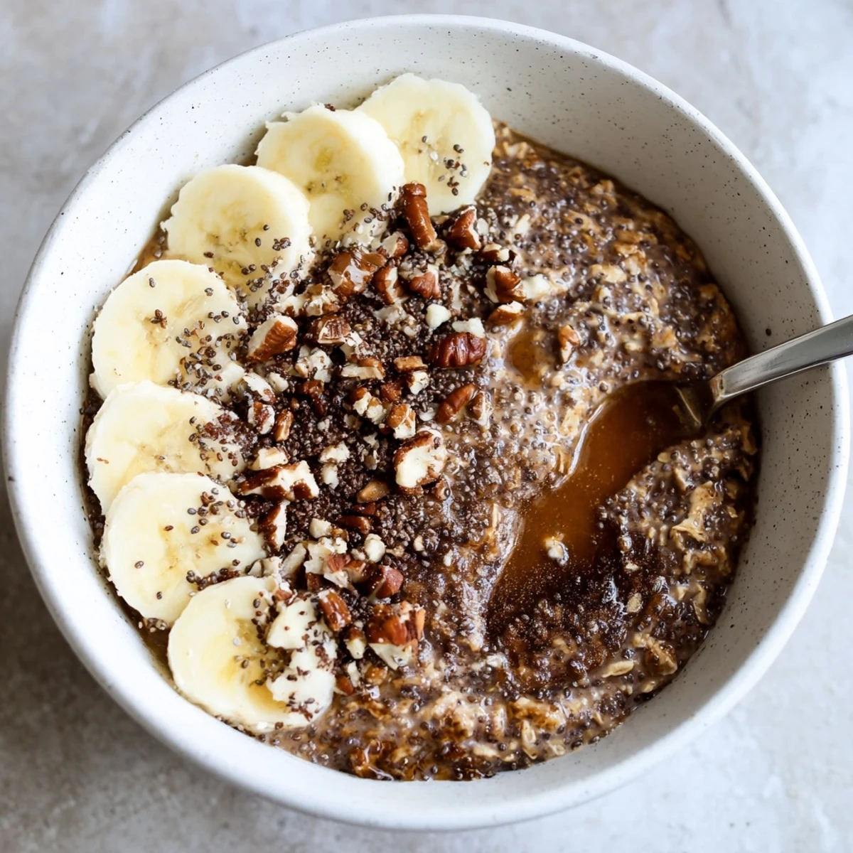 Brown Sugar Coffee Overnight Oats topped with sliced banana and toasted pecans