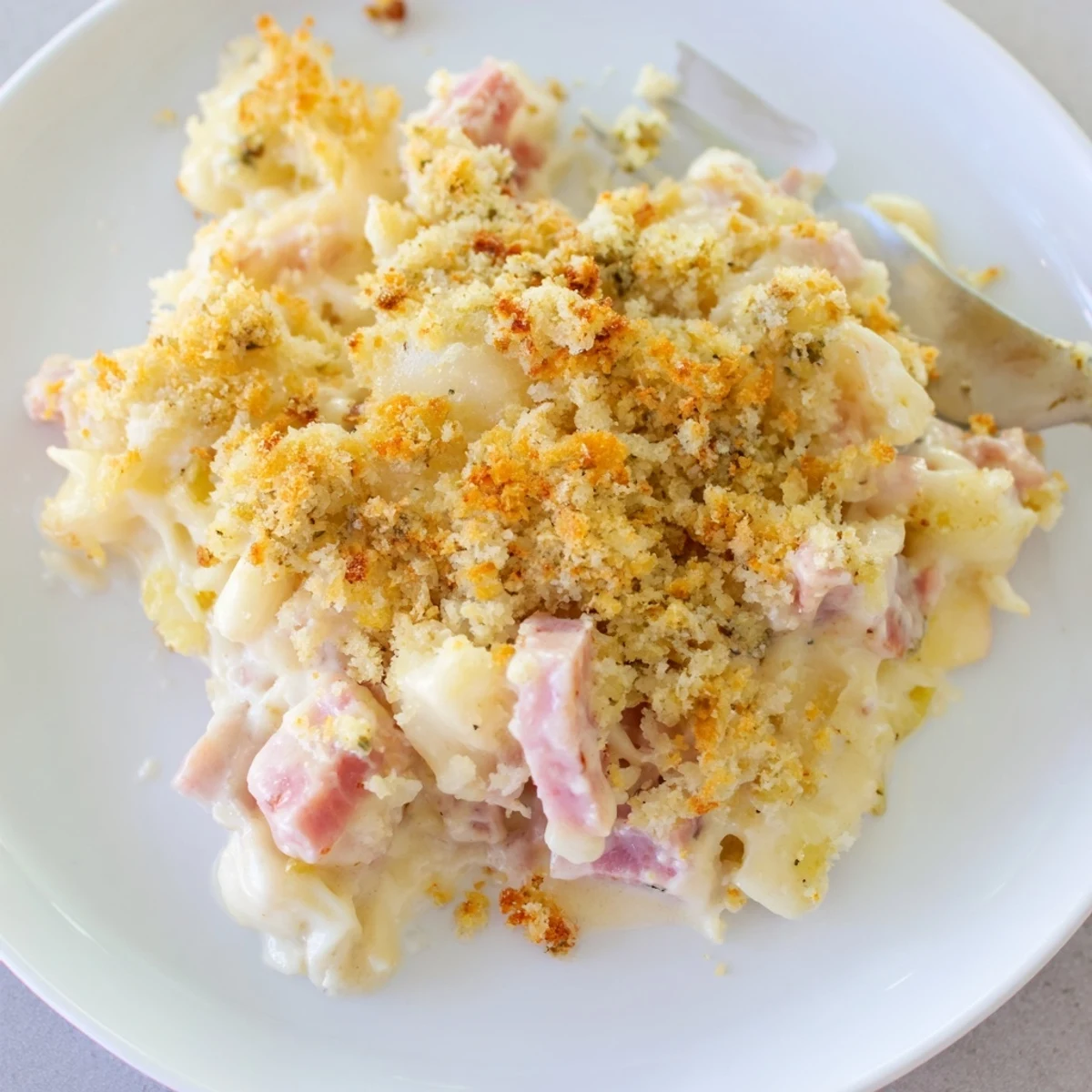 Aromatic baked Chicken Cordon Bleu Casserole, creamy Dijon sauce pooling around layers