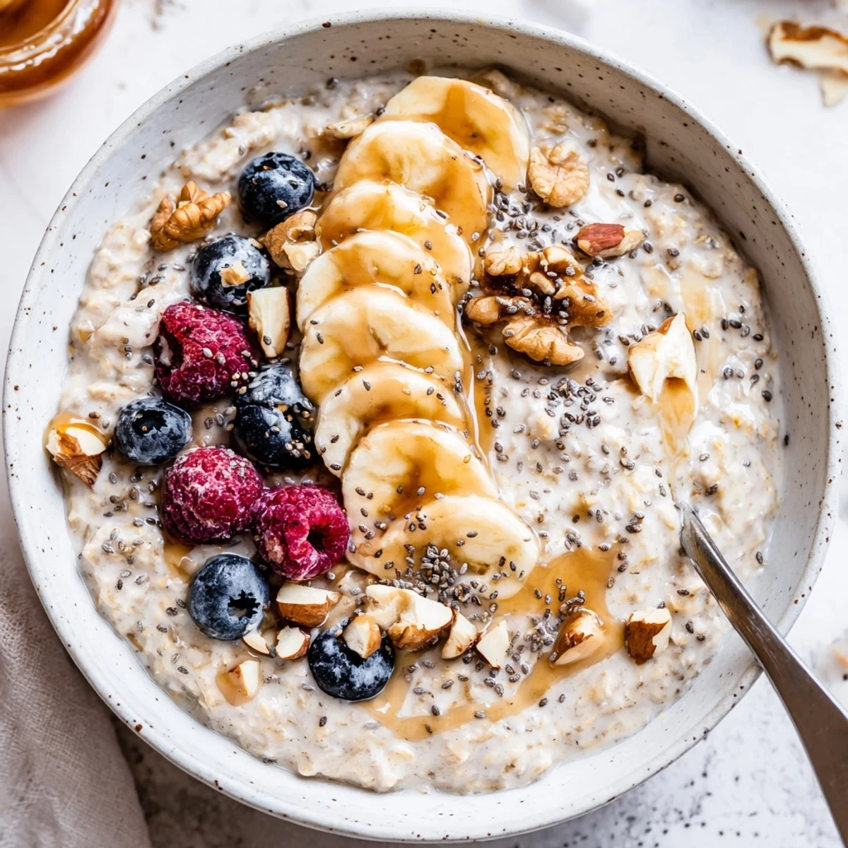 Warm bowl of Protein Oatmeal steaming after simmering, drizzled with maple syrup.
