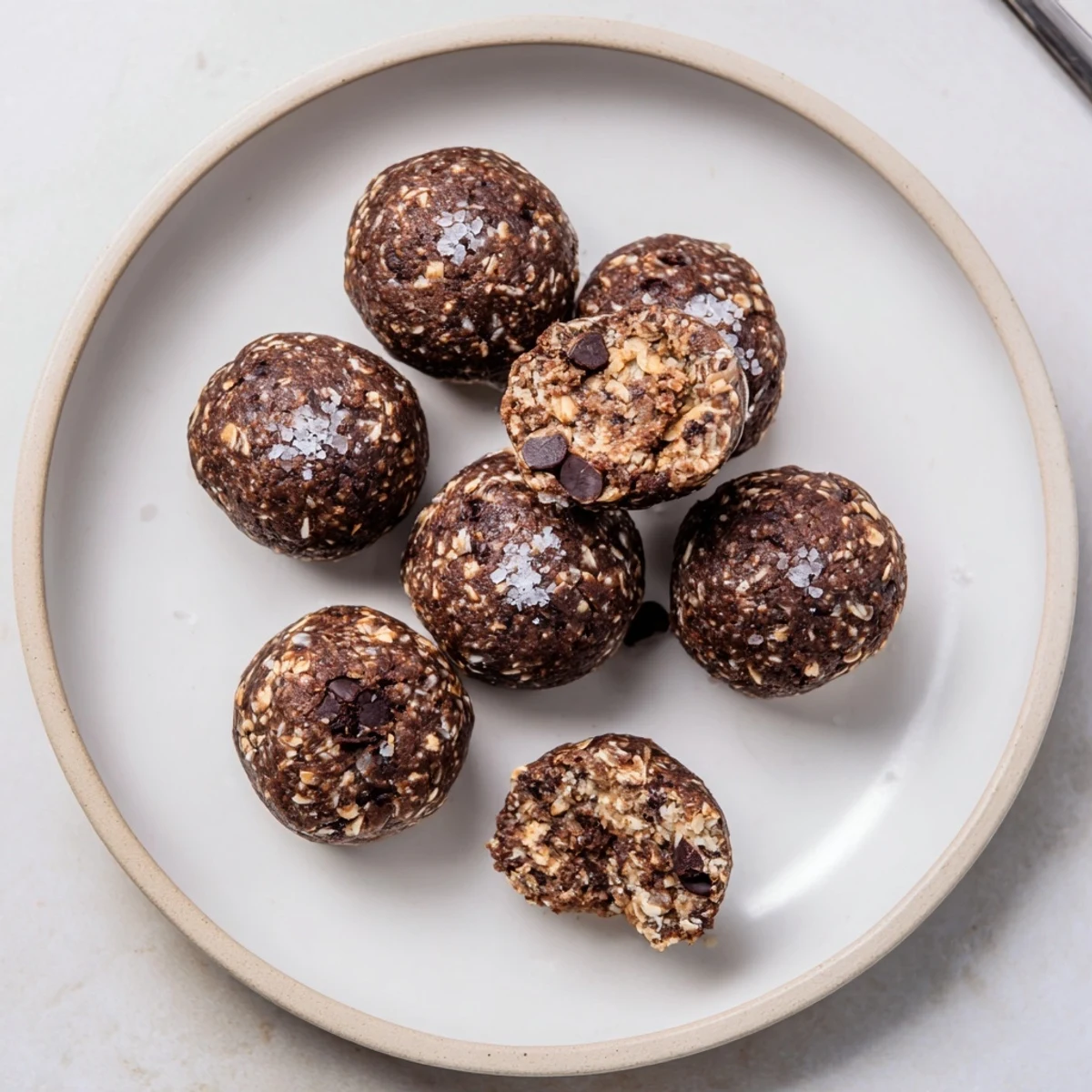 Brownie Protein Bites arranged on parchment, fudgy centers and glossy chocolate chips.