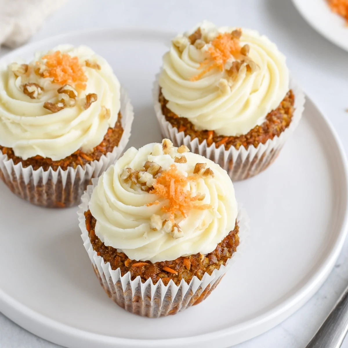 Stacked Moist Carrot Cake Cupcakes on a plate, tender crumb and spiced warmth.