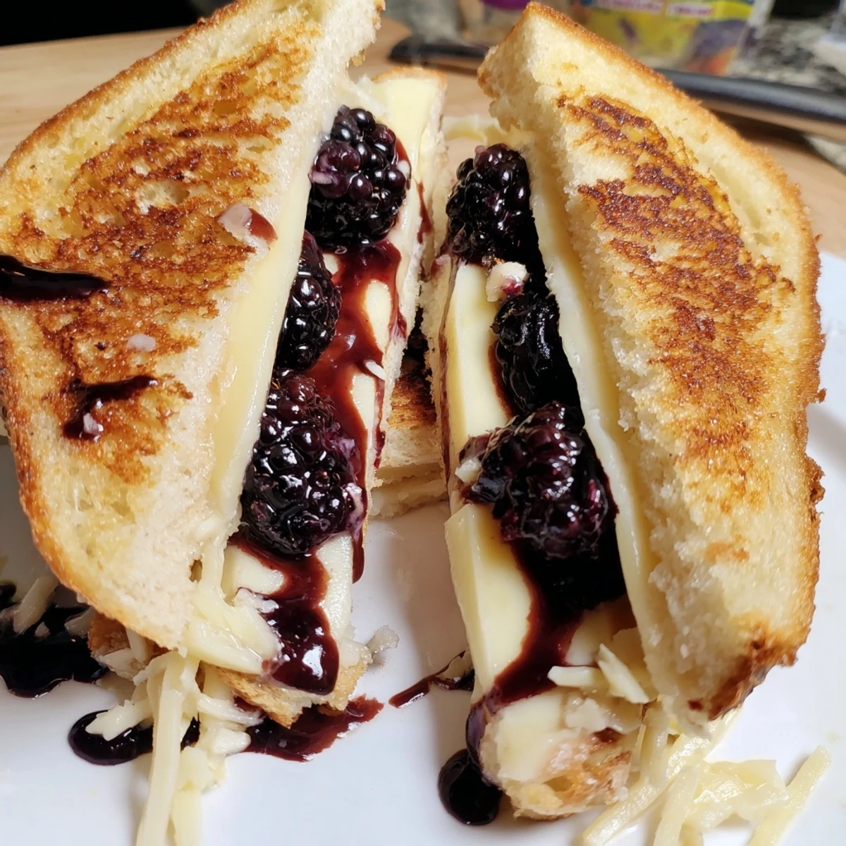 Toasted sourdough Balsamic Blackberry Bliss Grilled Cheese, gooey cheddar, tangy-sweet glaze