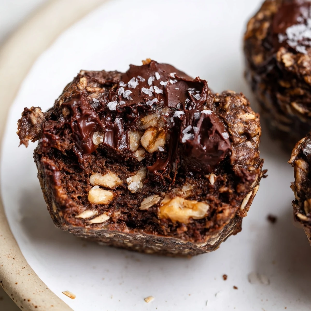 Stacked Decadent Dark Chocolate Oatmeal Cups dusted with cocoa and flaky sea salt.