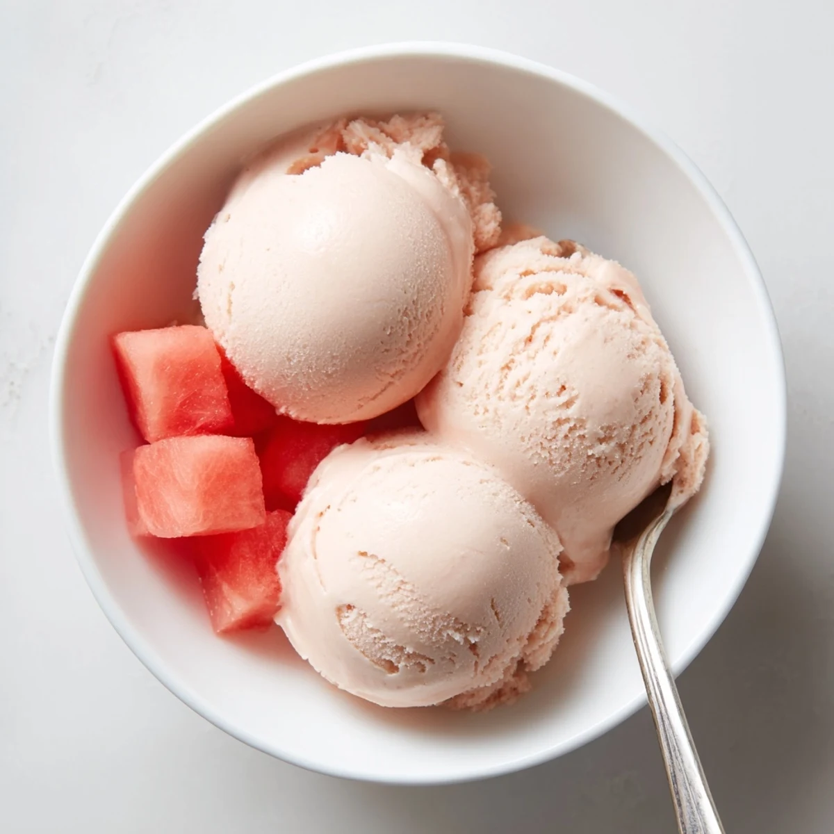 Pink watermelon ice cream swirled in a glass dessert cup ready to serve