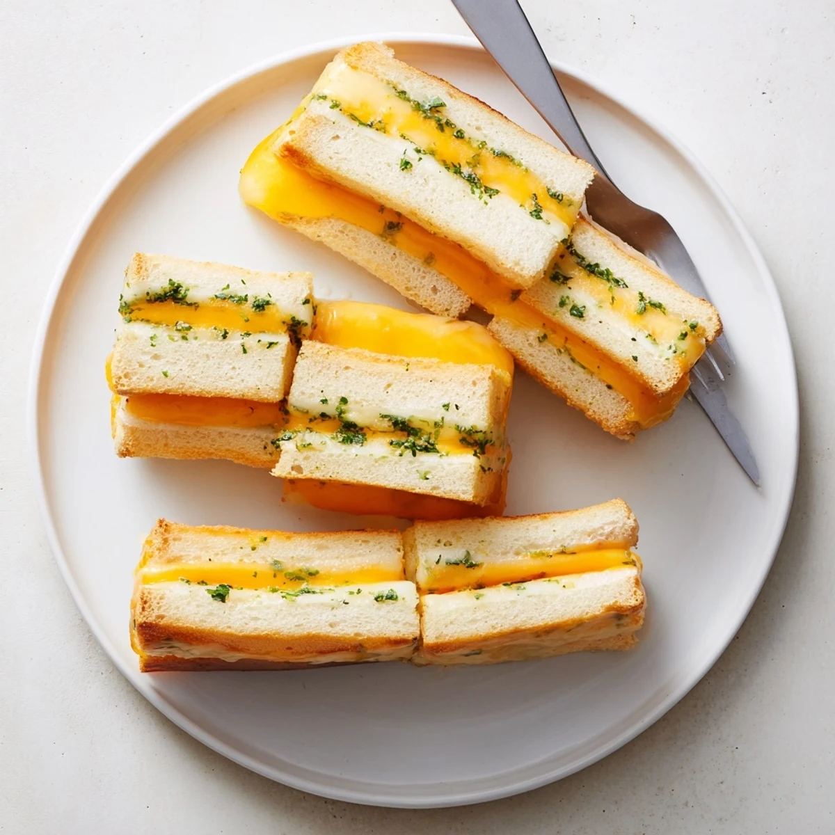 Warm Mini Grilled Cheese Hawaiian Rolls Recipe plated with tomato soup and parsley
