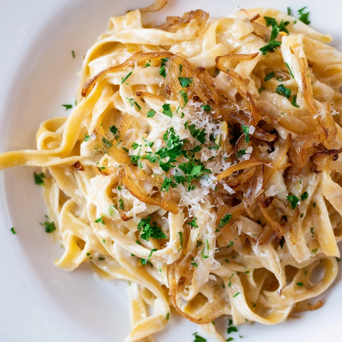 Fettuccine noodles tossed in rich Parmesan cream sauce with sweet caramelized onions