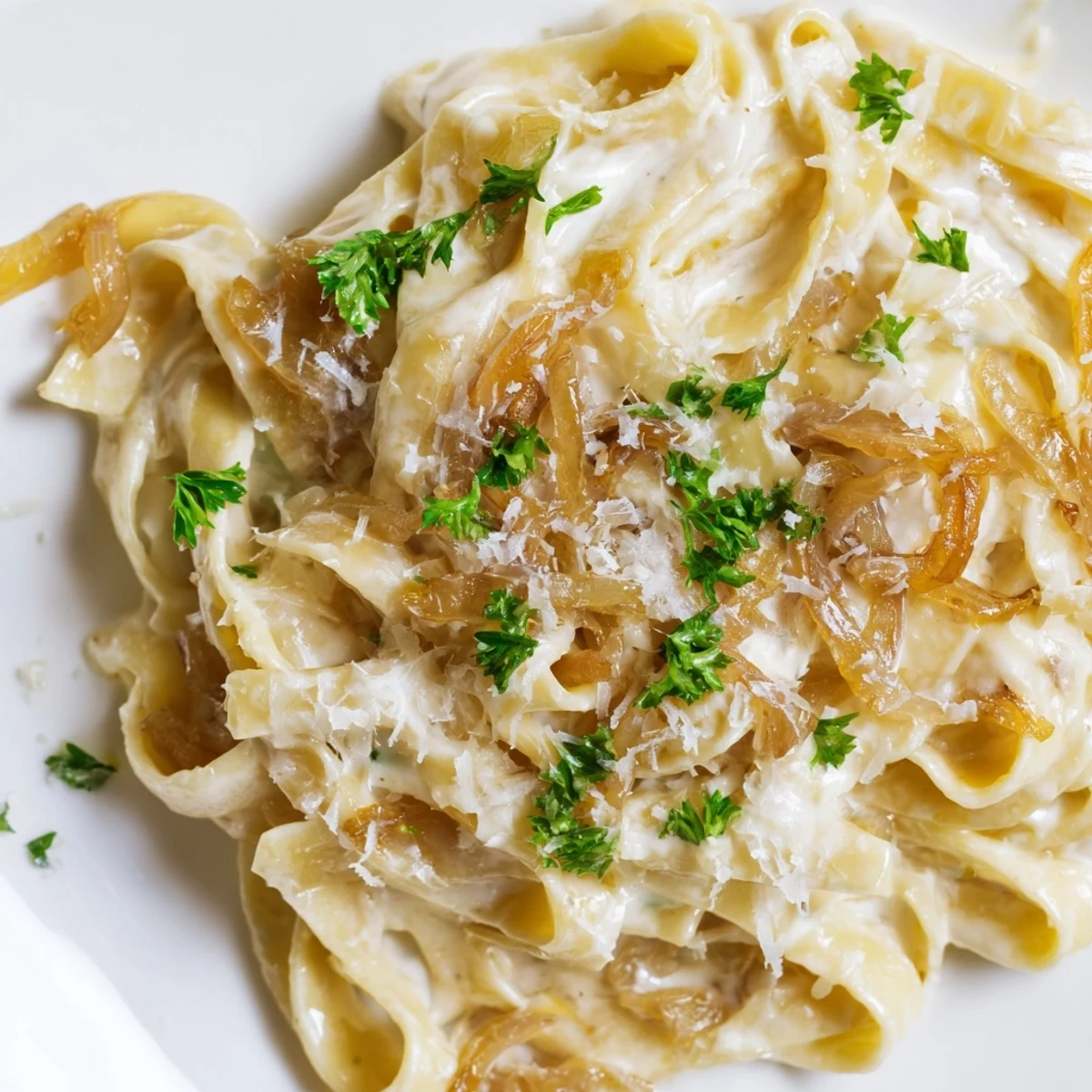 Creamy caramelized onion pasta with golden brown onions in velvety white sauce