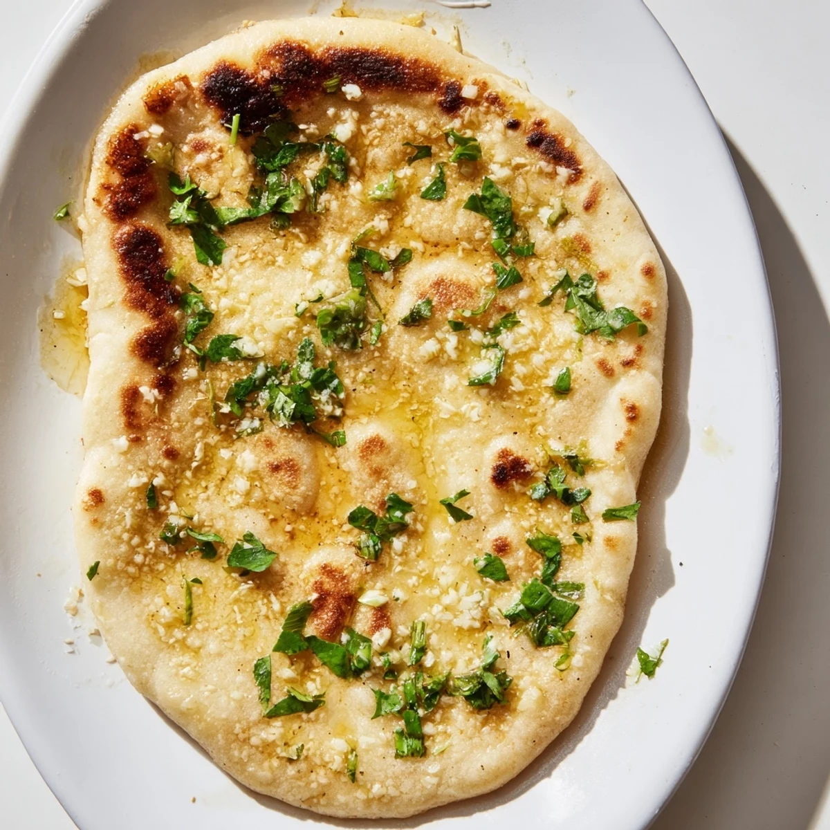 Warm sourdough discard soft naan bread piled high ready for dipping in curry